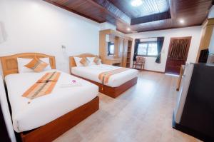 1 dormitorio con 2 camas y TV de pantalla plana en Coconut Grove Hotel Samui, en Koh Samui 
