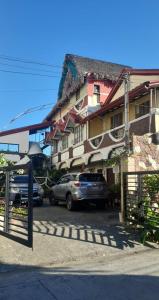 een gebouw waar auto's voor geparkeerd staan bij Casa Sarmiento Travellers Inn in Laoag