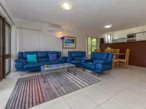 a living room with blue couches and a table at Tradewinds Unit 3 110 Victoria Parade in Nelson Bay