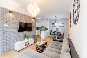 a living room with a couch and a brick wall at Apartament Solna 208 Kołobrzeg in Kołobrzeg