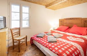 une chambre avec un lit, une chaise et une télévision dans l'établissement le chalet d'auguste 2 à 12 personnes, à Morzine
