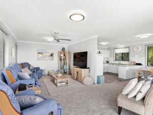 a living room with blue couches and a kitchen at Wahgunyah Road 50 in Nelson Bay
