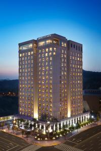 a large building with lights in front of a parking lot at LOTTE City Hotel Daejeon in Daejeon