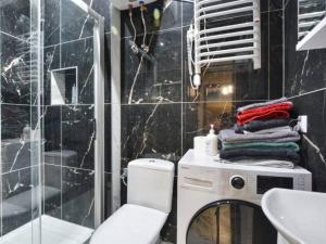 a bathroom with a sink and a washing machine at Apartament Folkowy Wujek pod Gromadzyniem in Ustrzyki Dolne