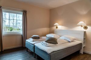 a bedroom with two beds and a window at Vesterålen Kysthotell in Stokmarknes +46 photos