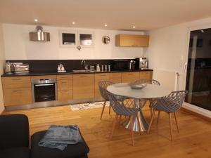 cocina con mesa y sillas en una habitación en Très bel appartement avec vue sur les montagnes, en Saint-Ismier