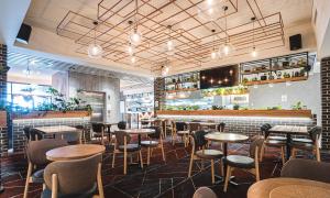 PeakhurstThe Peakhurst的有桌椅和酒吧的餐厅
