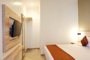 a hotel room with a bed and a flat screen tv at Victory Stay in Srondolwetan