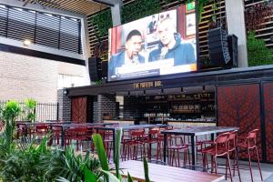 a restaurant with tables and chairs and a large screen at The Peakhurst in Peakhurst