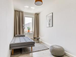 a living room with a ottoman and a window at limehome Chemnitz Hartmannstraße in Chemnitz