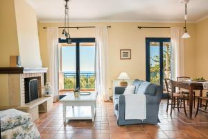 a living room with a fireplace and a table at Villa Rudi in Trapezaki