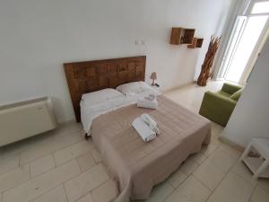 a bedroom with a large bed and a green chair at Sal.to nel blu in Leverano