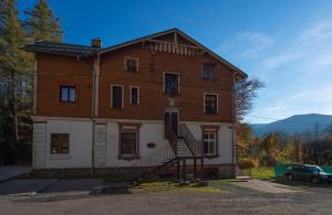 une ancienne maison en bois avec un escalier en face de celle-ci dans l'établissement Apartament z panoramą Szrenicy, à Szklarska Poręba