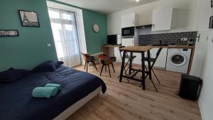 1 dormitorio con 1 cama y cocina con mesa en Segré centre ✰ studio ✰ 24m² ✰ cuisne ✰ wifi ✰ TOUT NEUF!, en Segré