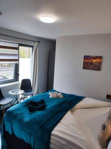 - une chambre avec un lit doté d'une couverture bleue dans l'établissement Pension zur Perle, à Büsum