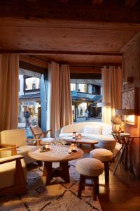 a living room with a couch and tables and chairs at Hotel Mont Blanc Megève in Megève