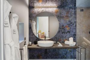 een badkamer met een wastafel en een spiegel bij Relais Antica Badia - San Maurizio 1619 in Ragusa