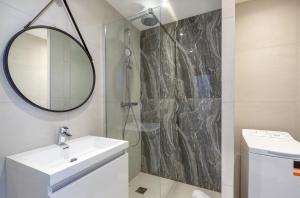 ein Badezimmer mit Waschbecken und Dusche mit Spiegel in der Unterkunft Agence des Résidences - Appartements privés du 45 CROISETTE - Superieur in Cannes + 23 Fotos