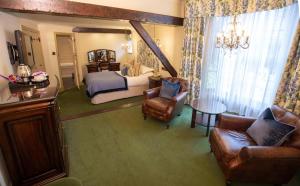 a bedroom with a bed and a couch and chairs at Bear Crickhowell in Crickhowell