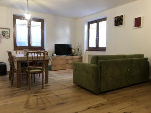 un soggiorno con divano verde e tavolo di 017 Trilocale, Pinzolo a Pinzolo