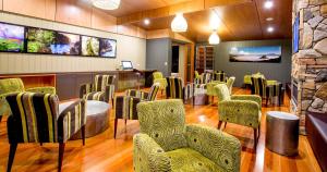 a waiting room with green chairs and a bar at BIG4 Tweed Billabong Holiday Park in Tweed Heads