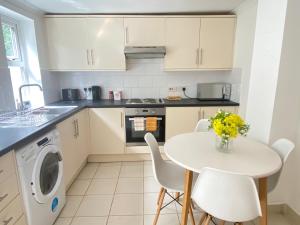 a kitchen with a white table and chairs and a sink at 4 Bed house sleeps 8 next to Chatham station and Chatham city centre in Chatham