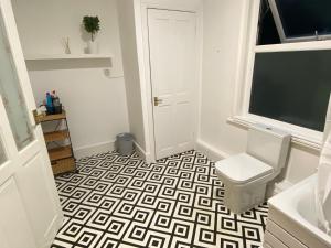 a bathroom with a toilet and a window at 4 Bed house sleeps 8 next to Chatham station and Chatham city centre in Chatham