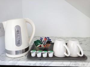 a counter with a coffee maker and cupcakes on a tray at Mill Studio A - Self contained one bed studio flat in Oxford