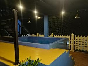 a large pool with a yellow floor in a room at Le Petit Hotel & Restaurant in Negombo