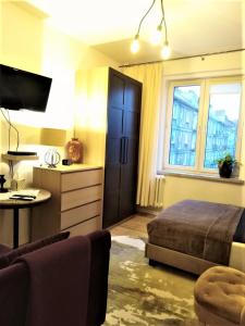 sypialnia z łóżkiem, biurkiem i telewizorem w obiekcie Wygodny Apartament w Śródmieściu Gdańska w Gdańsku