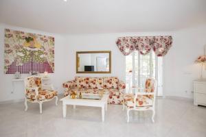 a living room with a couch and chairs and a table at Menorca Villa Marbella in Son Parc