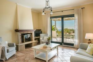 a living room with a fireplace and a table at Villa Petri in Trapezaki +17 photos