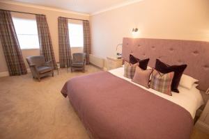 a bedroom with a large bed with pillows at Bear Crickhowell in Crickhowell