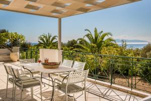 a patio with a table and chairs on a balcony at Villa Petri in Trapezaki