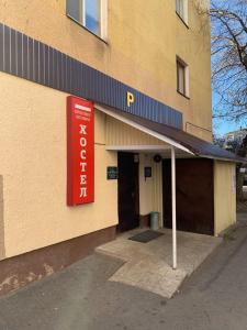 a building with a red sign on the side of it at Мини Гостиница Richotels in Ufa