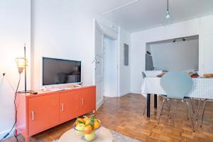 een woonkamer met een televisie en een tafel met een fruitschaal bij Gîte Le Colombier Sélestat - 30min EuropaPark in Sélestat