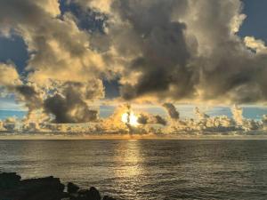 a cloudy sky over the ocean with the sun setting at 南灣陽光皮小妞 Pii hostel in Nanwan