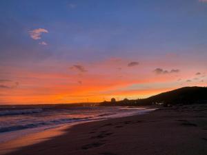 a sunset on a beach with the ocean at 南灣陽光皮小妞 Pii hostel in Nanwan