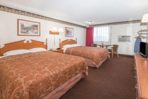 um quarto de hotel com duas camas e uma mesa em Super 8 by Wyndham Laramie em Laramie