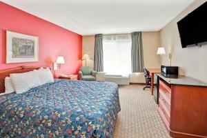 um quarto de hotel com uma cama e uma televisão em Days Inn by Wyndham Marietta-Atlanta-Delk Road em Marietta