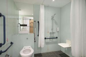 a bathroom with a toilet, shower, and sink at Ramada by Wyndham Belfast in Belfast