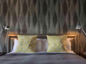 a bedroom with a bed with yellow and white pillows at Hotel St Moritz Queenstown - MGallery by Sofitel in Queenstown