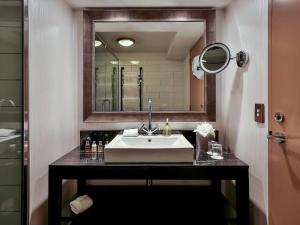a bathroom with a sink and a mirror at Hotel St Moritz Queenstown - MGallery by Sofitel in Queenstown