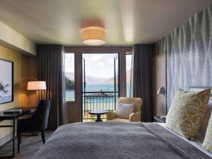 a hotel room with a bed and a view of the water at Hotel St Moritz Queenstown - MGallery by Sofitel in Queenstown
