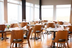 a dining room with tables and chairs and windows at Fosshotel Stykkisholmur in Stykkishólmur