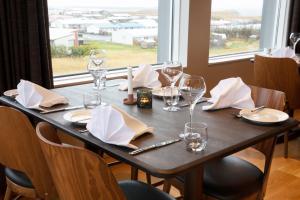 a wooden table with wine glasses and napkins on it at Fosshotel Stykkisholmur in Stykkishólmur