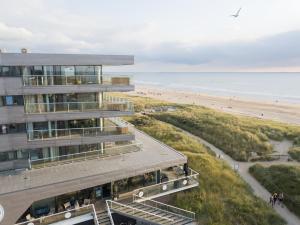 um edifício com uma praia ao fundo em Maris Apartments em Egmond aan Zee