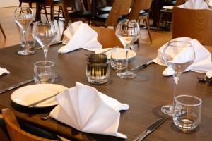 a wooden table with wine glasses and napkins on it at Fosshotel Stykkisholmur in Stykkishólmur