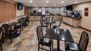 a restaurant with tables and chairs and a kitchen at Best Western Lapeer Inn in Lapeer