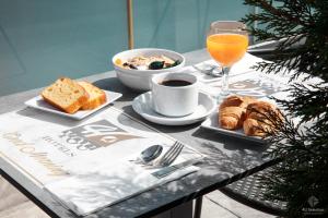 - une table avec des aliments pour le petit-déjeuner et un verre de jus d'orange dans l'établissement 4-you Boutique, à Metamórfosi